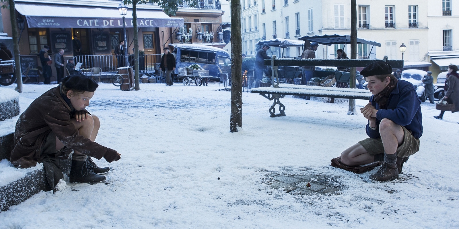 Cena do filme com os dois irmãos jogando bolinha de gude em um chão cheio de neve