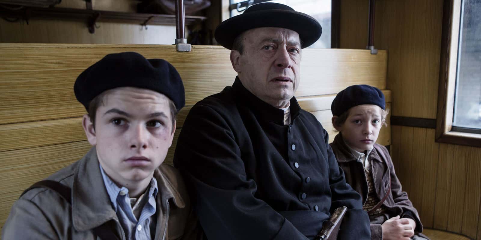Cena da adaptação cinematográfica, em que o padre salva as duas crianças no trem