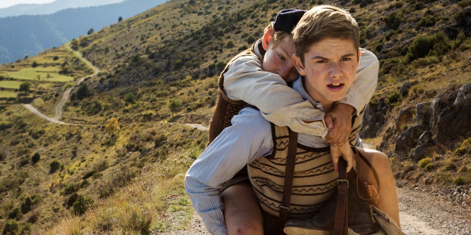 Cena do filme de 2017, com Maurice carregando Joseph por uma estrada de terra, no meio das montanhas