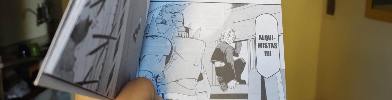Foto do mangá, mostrando Edward e Alphonse dentro de um trem. Edward está na janela, pronto para sair por ela, dizendo ALQUIMISTAS